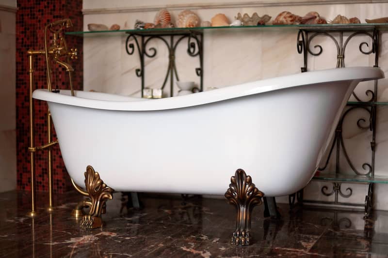 RHB Assets From IGX: Vintage clawfoot tub in a bathroom with natural light and classic decor.