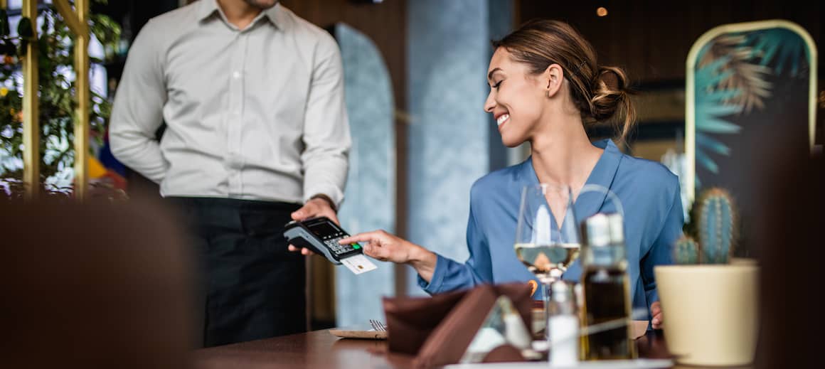 A woman paying the check at a restaurant.