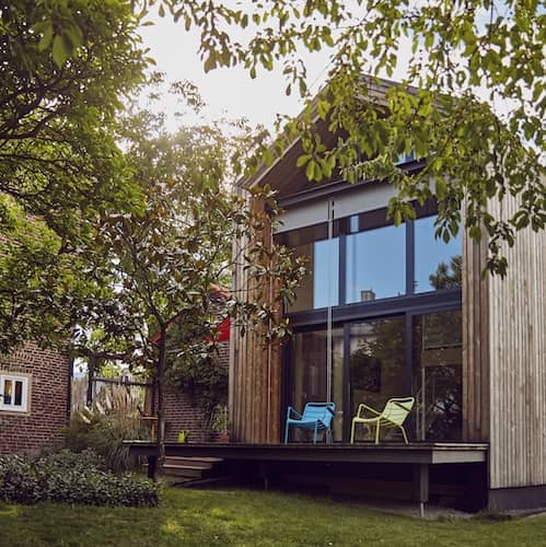 Exterior of modern home with two story picture windows.