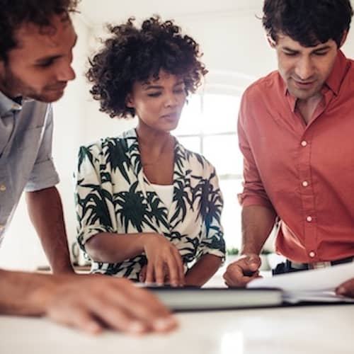 Couple meeting with realtor, reviewing paperwork.