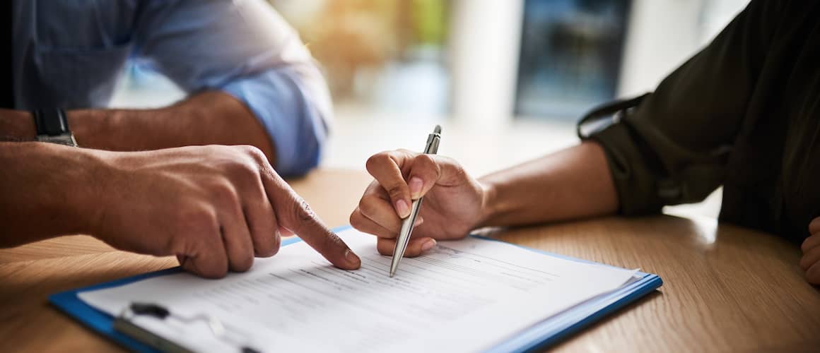 RHB Assets From IGX: Woman signing paperwork at desk