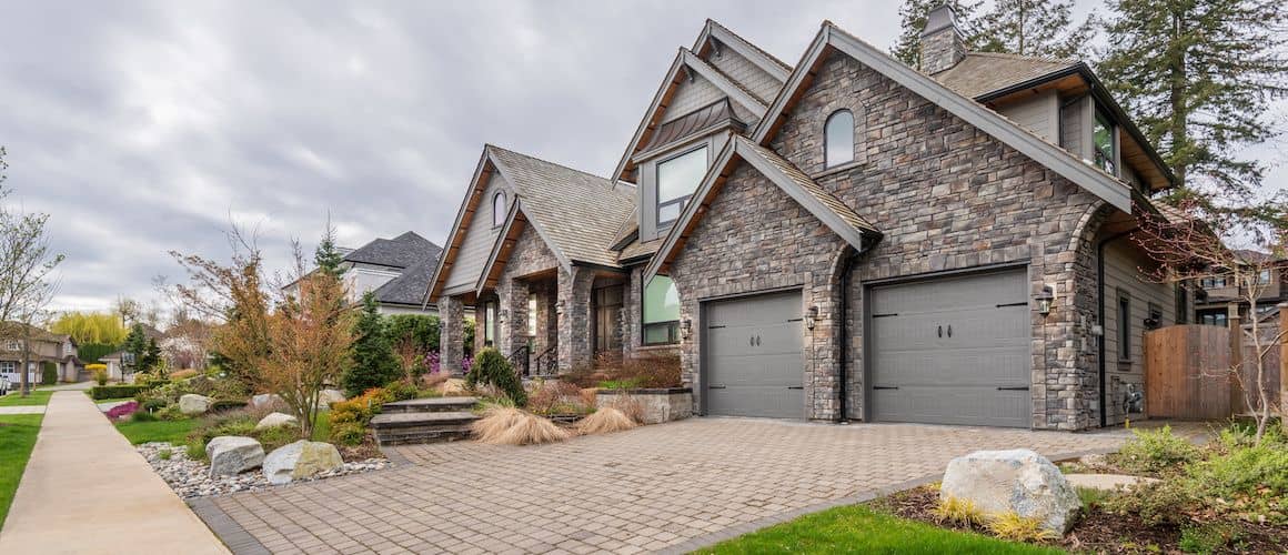 A large stone house with a stone driveway, showcasing a grand residential property.