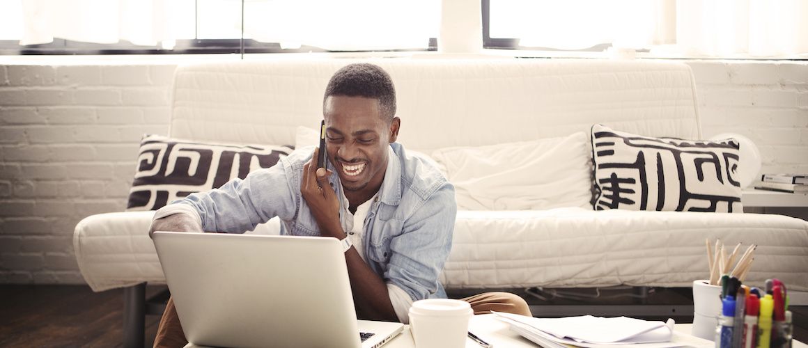 A man talking on the phone in a living room setting.