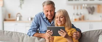 RHB Assets From IGX: Elderly couple using a tablet together, smiling and engaged.