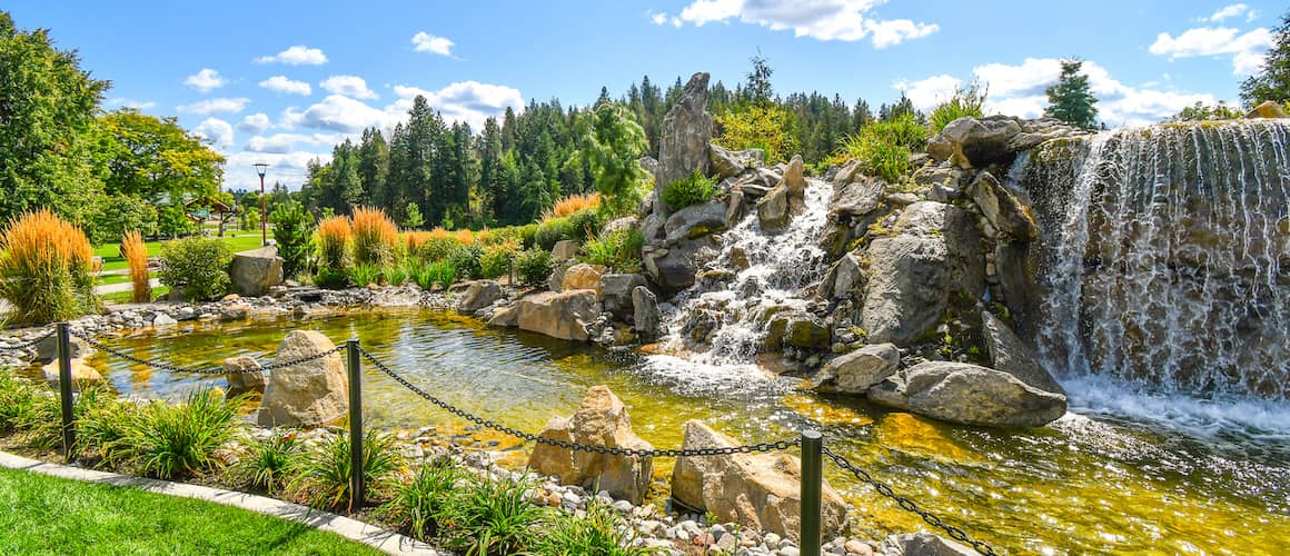 RHB Assets From IGX: Serene pond with a dock in Coeur d'Alene, Idaho, surrounded by trees.