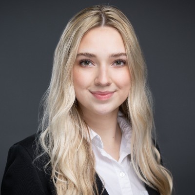 Headshot of a blonde woman against a grey background.