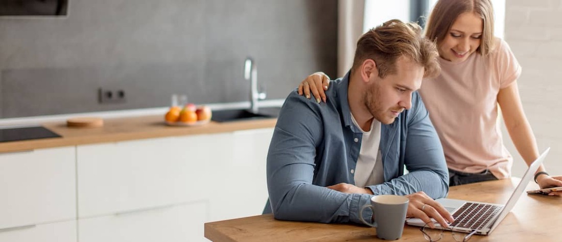 Stock-Couple-In-Kitchen-With-Laptop-And-Coffee-AdobeStock231024079 copy.jpg