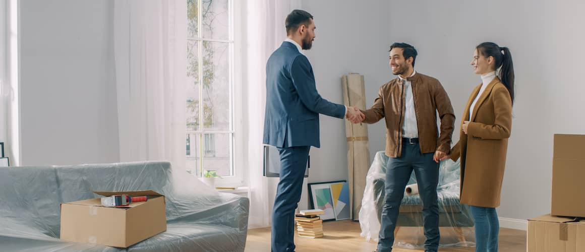 A couple with a real estate agent, engaged in discussion, possibly viewing a property or discussing home options.