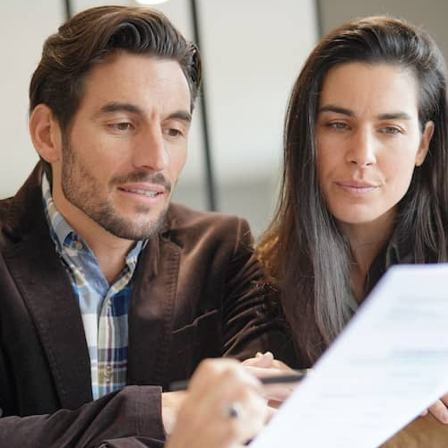 A couple discussing terms and condition possible for mortgage or related to real estate with an agent.