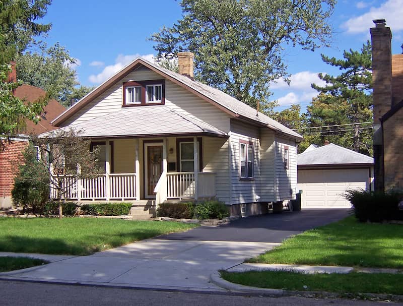 Exterior view of a tan and brown bungalow style single family home.