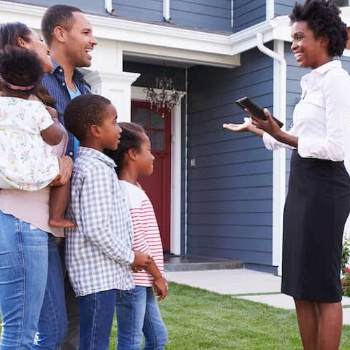 A real estate agent showing a family a house.