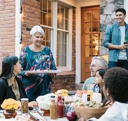 A family gathered around a table, eating and drinking together.
