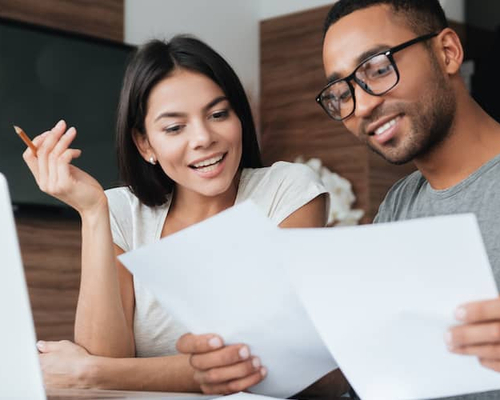 Young couple looking at papers together at home.