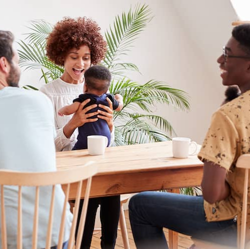 A diverse group of individuals gathered around a table, engrossed in conversation.