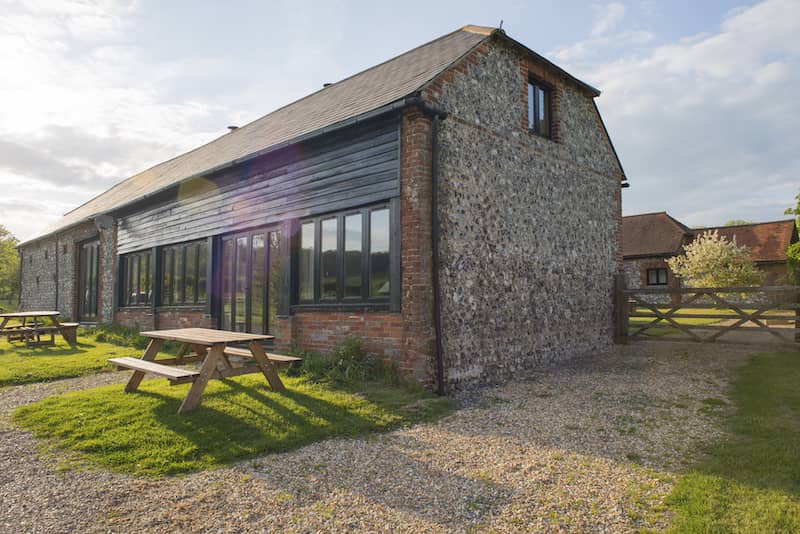 RHB Assets From IGX: Rustic barn with a weathered wooden exterior surrounded by a field