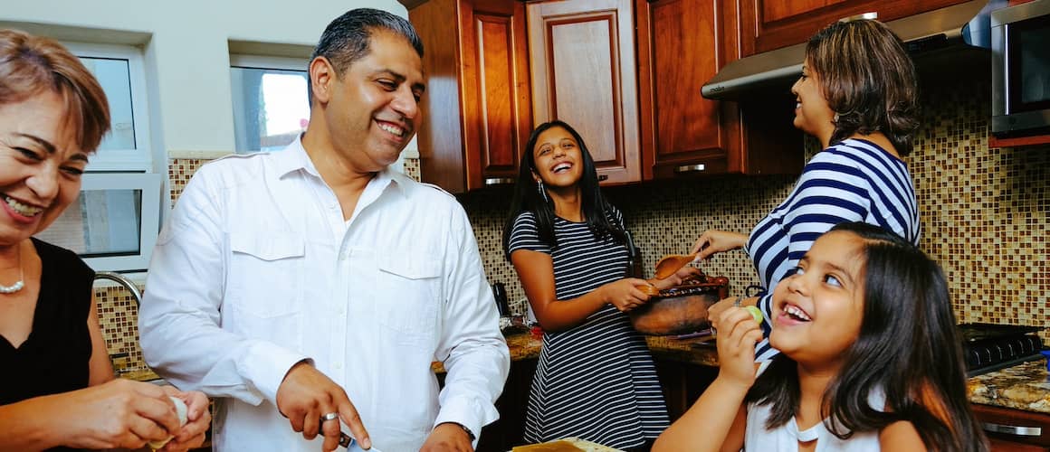 Family preparing food to eat in the kitchen together.