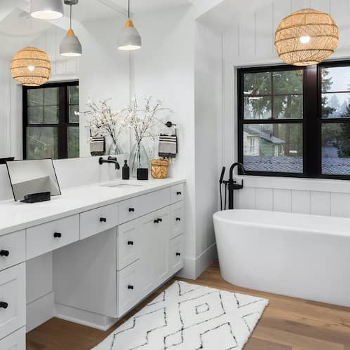 Bathroom mid-renovation with new white tile and dark wood vanity.