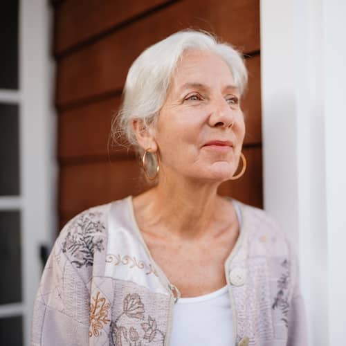 Woman looking off into distance smiling softly.