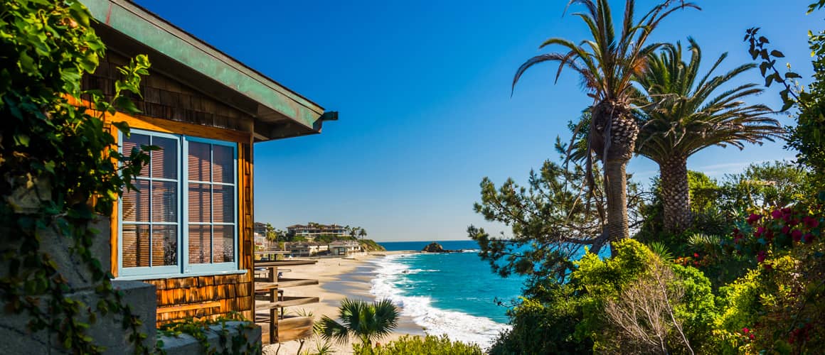 A beach house nestled amidst palm trees, offering a breathtaking view of the ocean.