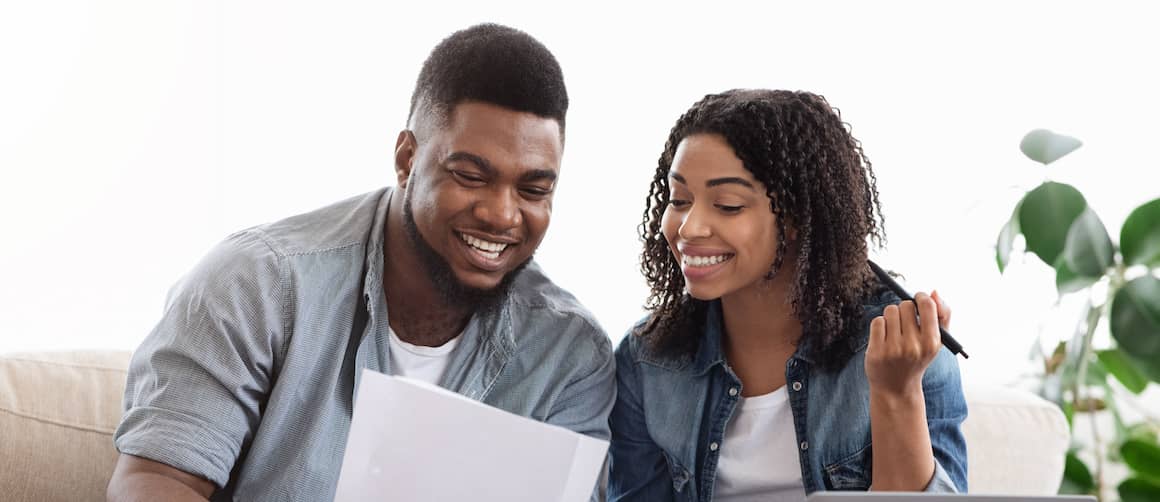 Happy couple discussing something on papers.