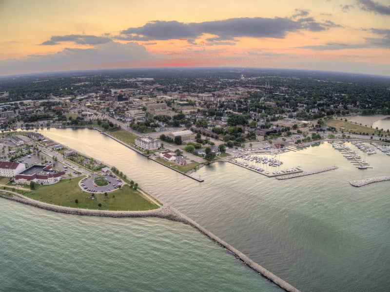 RHB Assets From IGX: Aerial sunset view of Sheboygan, Wisconsin, showcasing waterfront and cityscape