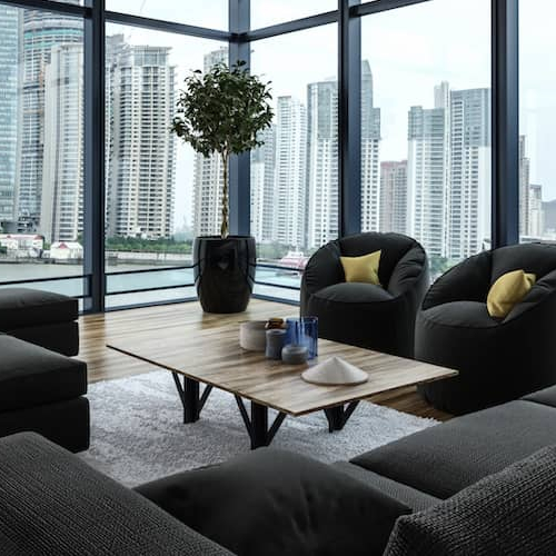 A modern neutral-colored living room with large windows and stylish furniture.