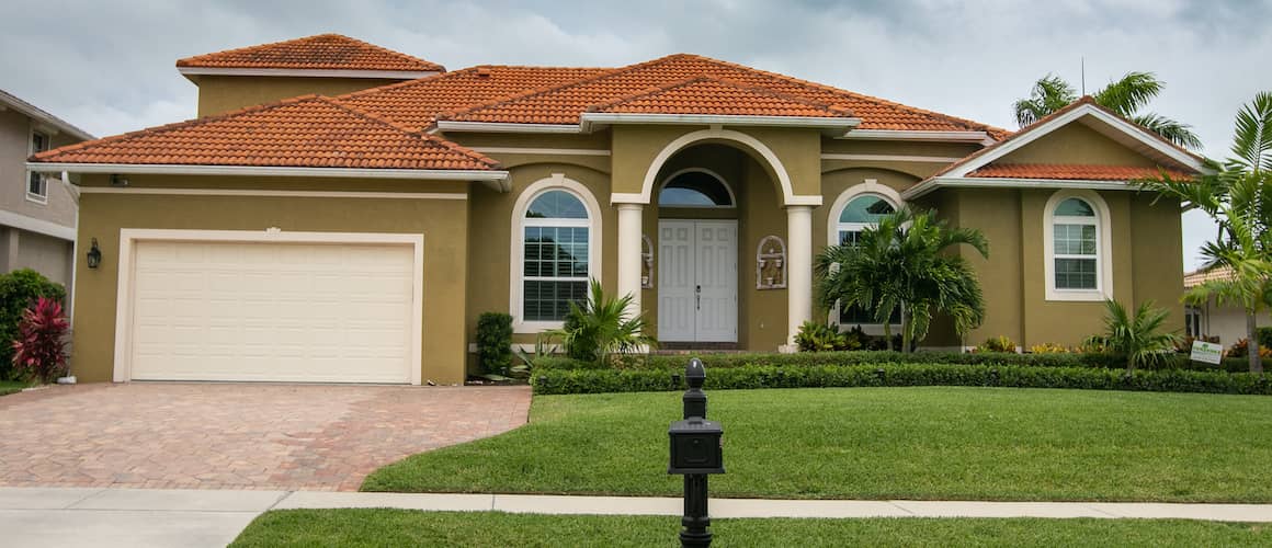 An olive green home with a terracotta roof, displaying distinctive exterior design elements.