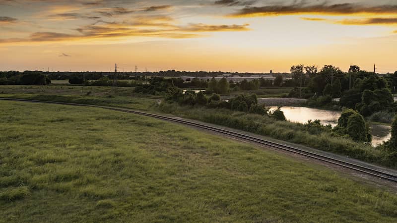 Field and railroad tracks in front of the small town, Sugar Land, Texas.