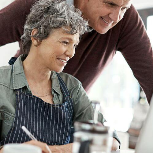 Middle-aged couple creating a budget, possibly discussing refinancing costs or financial planning.