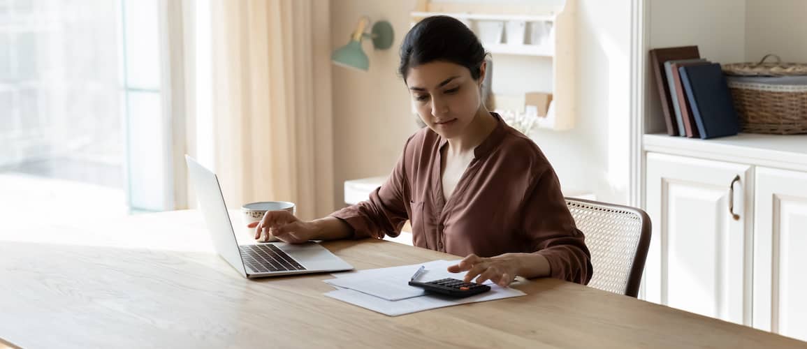 Young woman at table working on her finances.