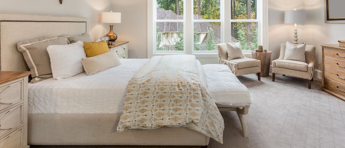 A well-lit white master bedroom, potentially depicting home interior design or real estate staging.