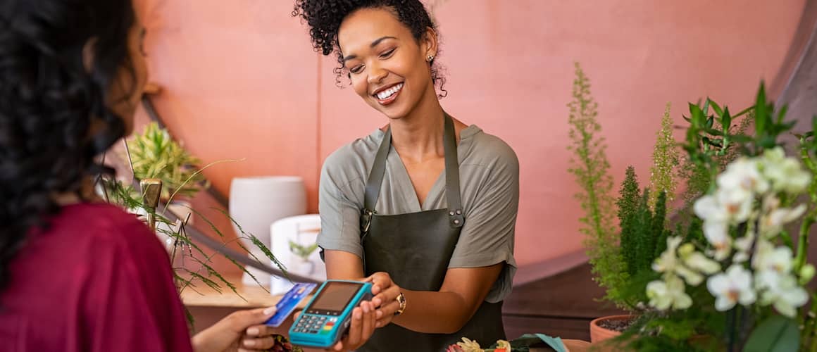 Customer paying with contactless credit card at flower shop