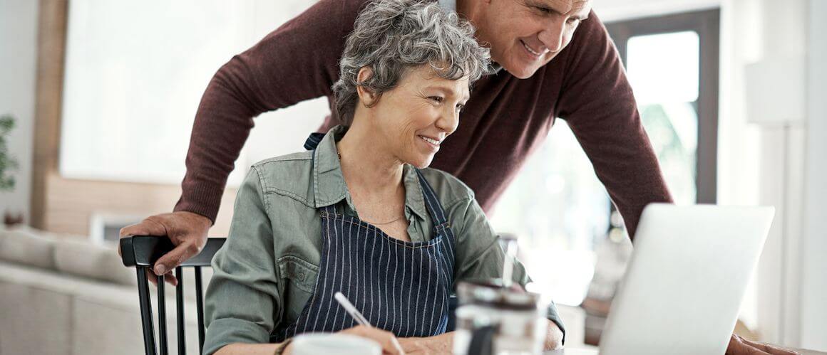 Middle-aged couple creating a budget, possibly discussing refinancing costs or financial planning.