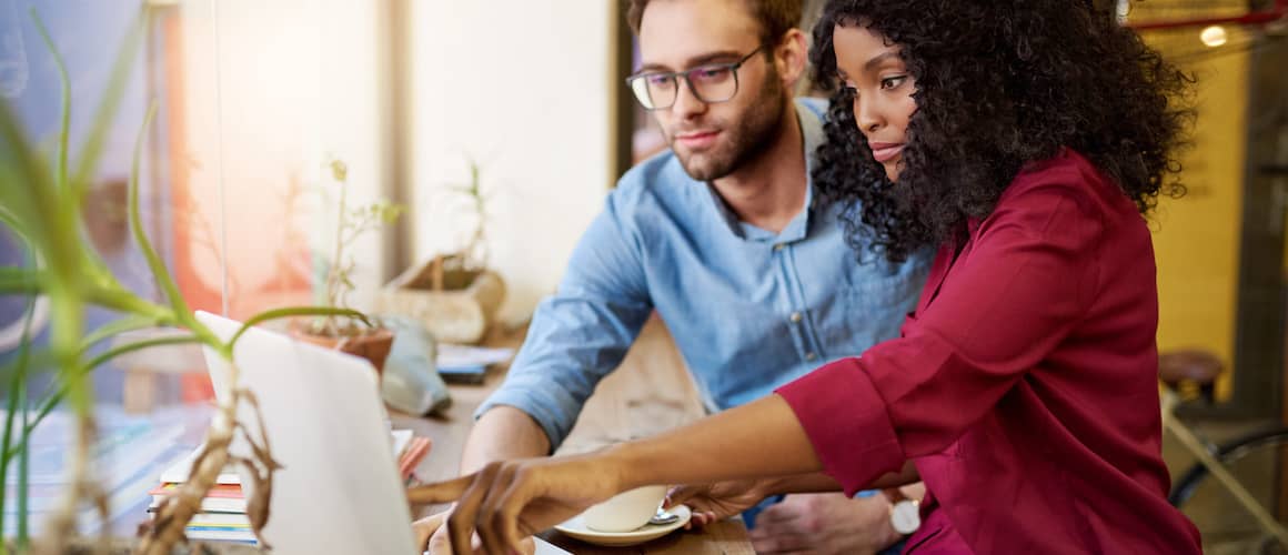 A couple pointing at a laptop, suggesting discussions or decisions related to real estate or finances.