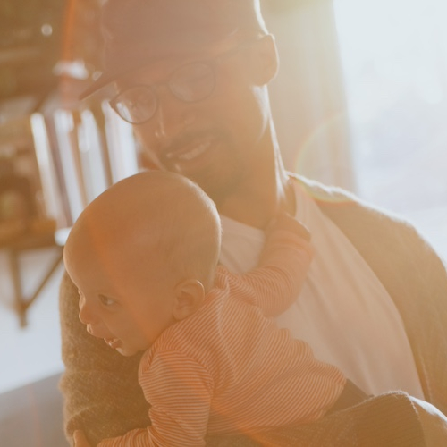 Mother looking at baby being held by father in their cozy home.