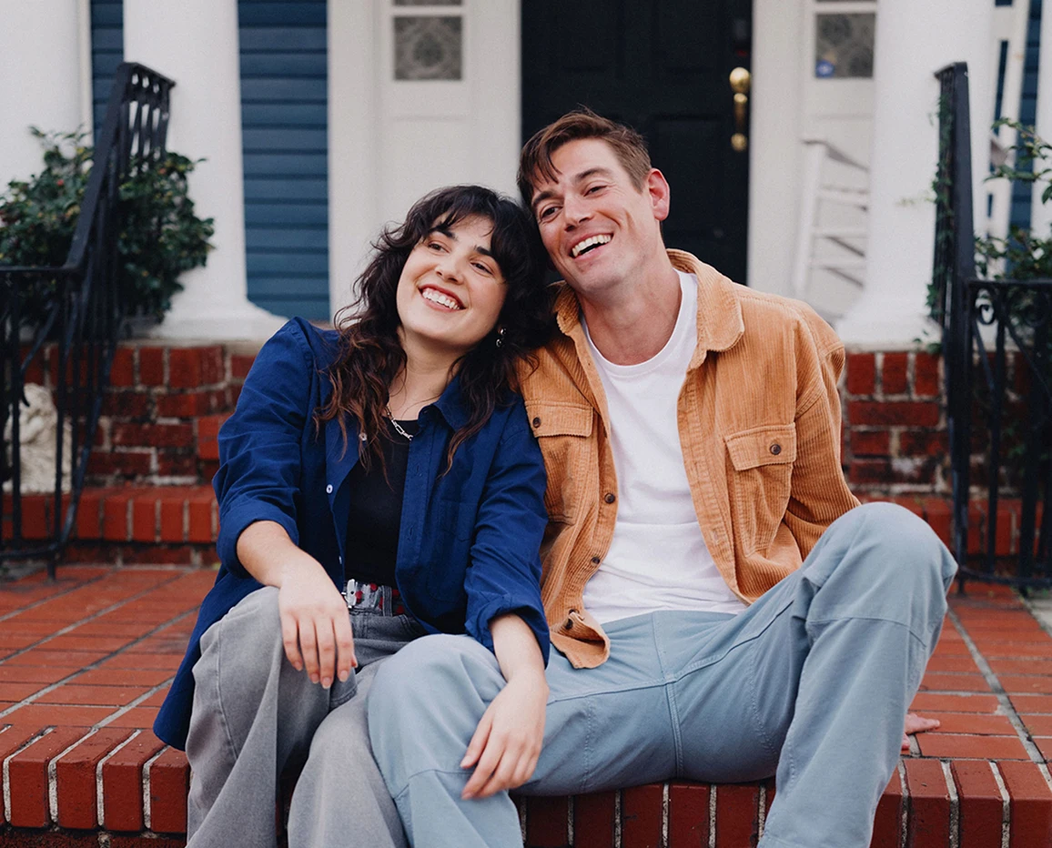Couple sitting together on front steps.
