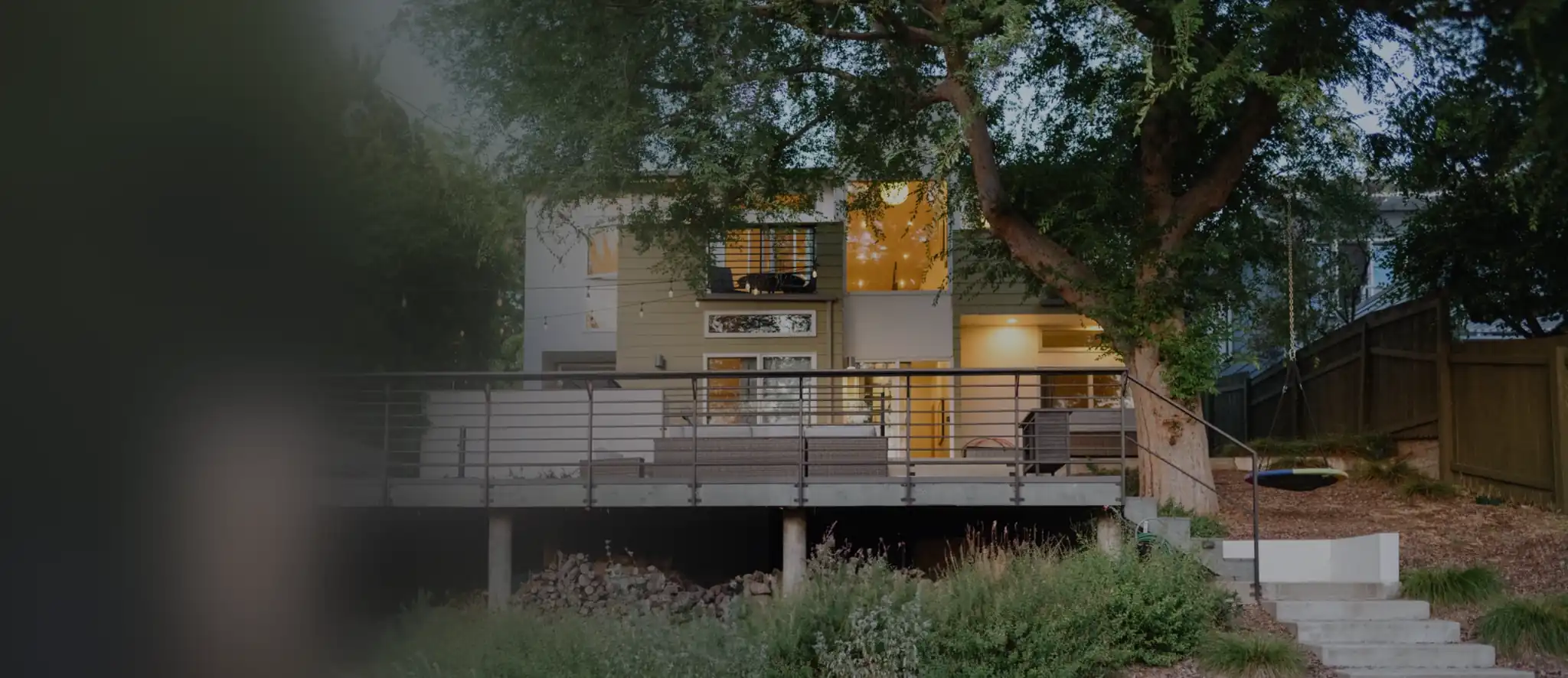 Modern hillside home with landscaping in the evening.