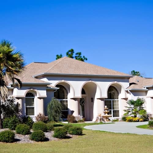 White ranch home with palm tree landscaping in Florida.