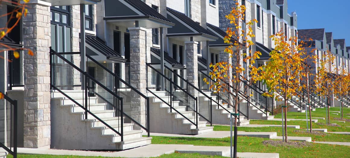 RHB Assets From IGX: Row of modern duplex houses with green lawns and blue sky