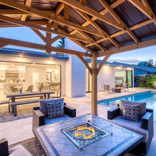 Backyard patio of a home with a firepit and a pool.