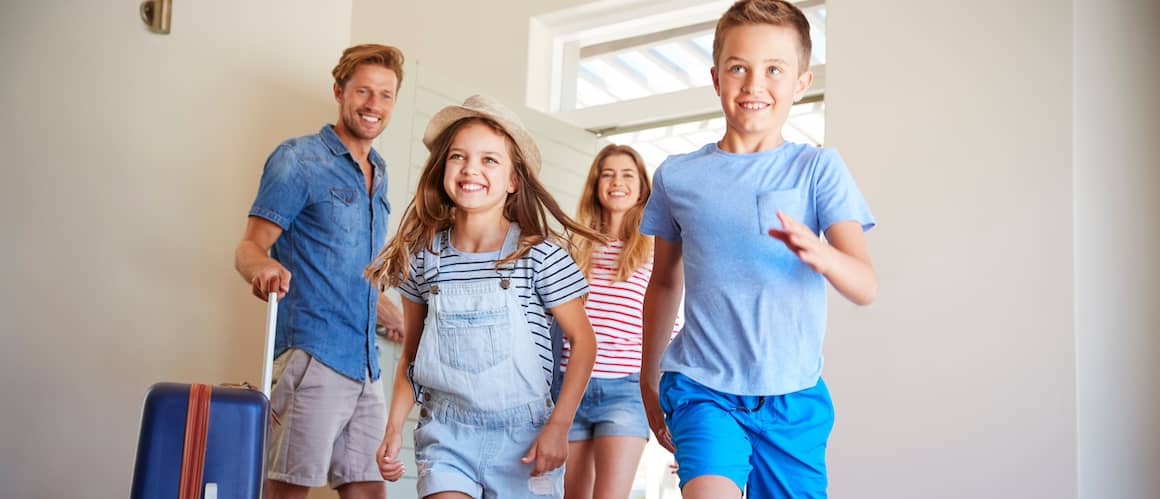 Family Arriving At Summer Vacation Rental