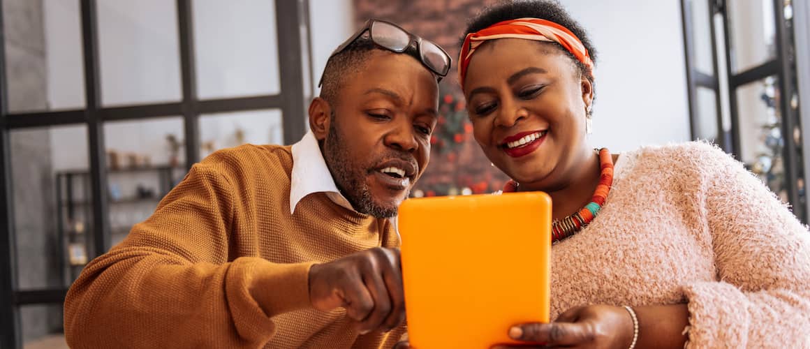 A man and women discussing something on a tab.