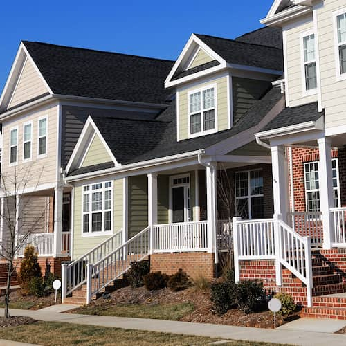 Image displaying a row of townhouses on a sunny day in North Carolina, showcasing real estate or property.