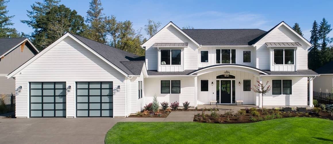 The exterior of a white house during the day, showcasing a residential property.