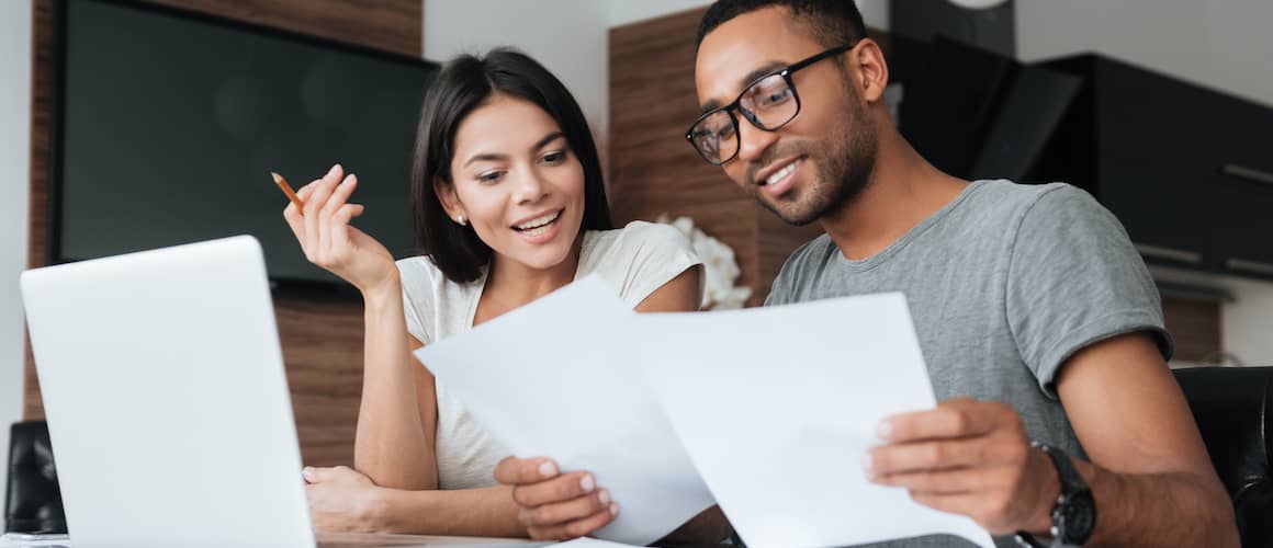 Young couple looking at papers together at home.