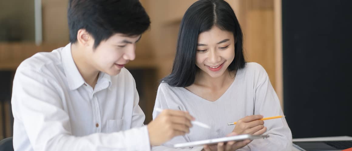 An Asian couple looking at a tablet together.