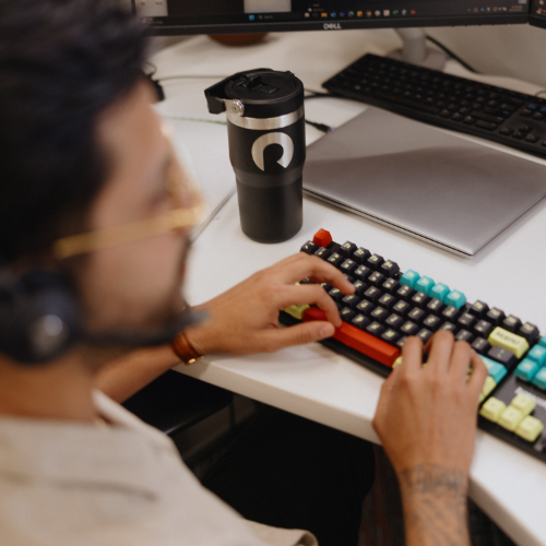 Team member with headphones on and hands on keyboard.