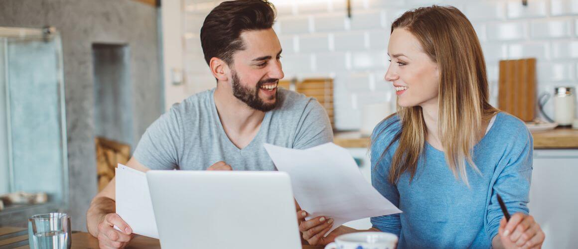 A couple paying bills at a table, finances.