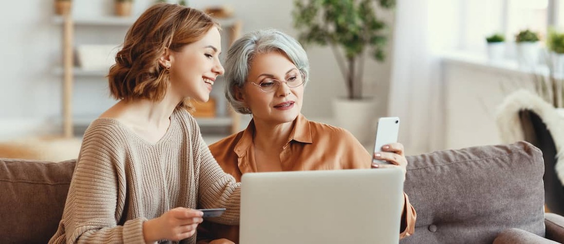 Mother and daughter shopping together online.