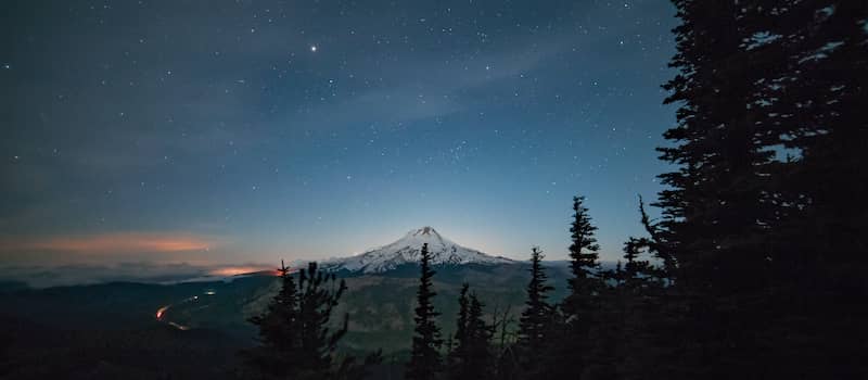 Upper Hood River Valley seen at night with clear skies and silhouetted trees.